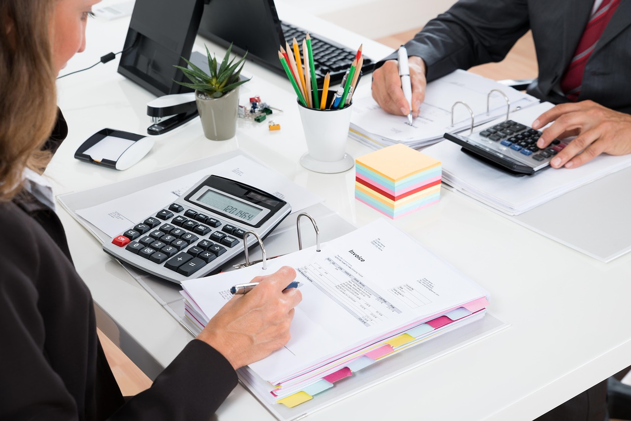 電卓と書類を前にオフィスで税務書類を確認する様子